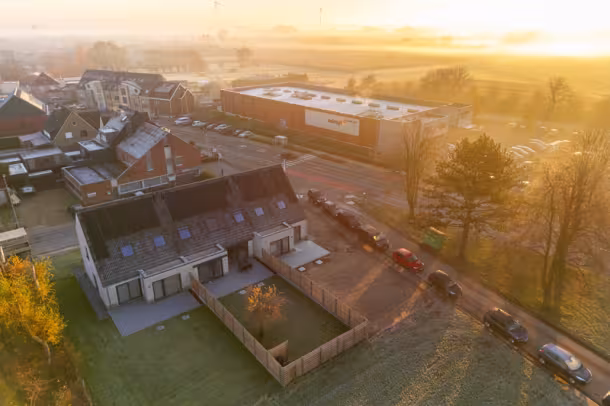 Dronebeeld bij zonsondergang van woonwijk met nieuwbouwwoningen, Hectaar project