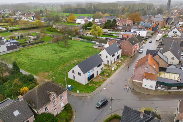Dronebeeld van woonwijk met nieuwbouwwoningen en groen in Erpe-Mere