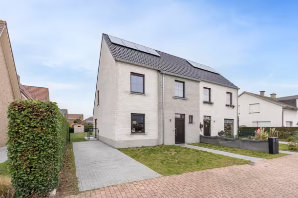 Straatbeeld van moderne nieuwbouwwoning met oprit en voortuin, Hectaar woning in De Haan
