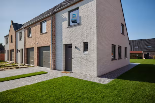 Voorgevel van nieuwbouwwoning in Poperinge met garage en oprit