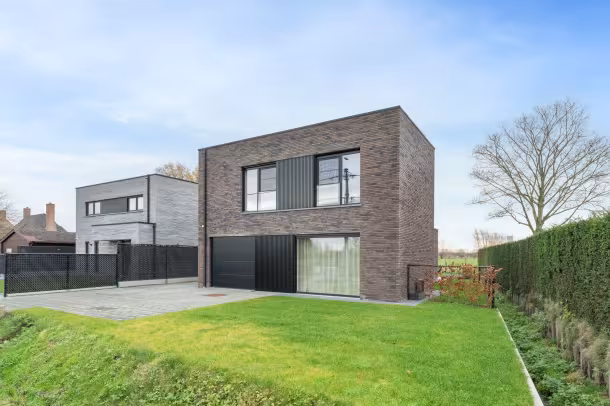 Voorgevel van moderne Bouwen Op Maat woning met terras en grote tuin in Laarne