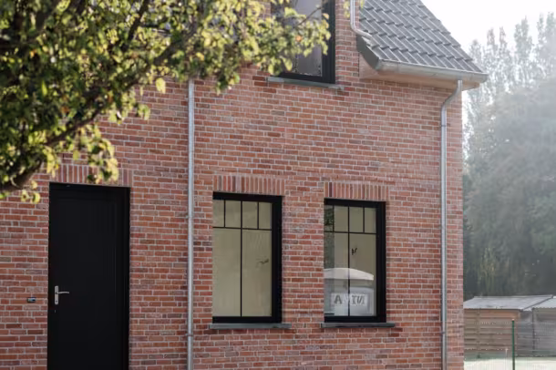 Zijaanzicht van Bouwen Op Maat nieuwbouwwoning met zwarte deur en ramen