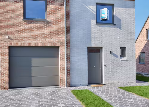 Voorgevel van nieuwbouwwoning in Poperinge met garage en oprit