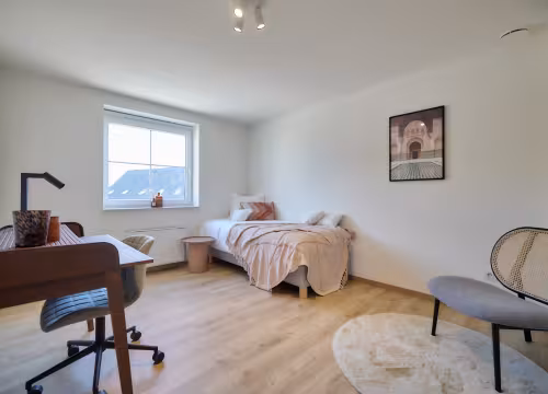 Slaapkamer met dubbel bed, bureau en houten vloer