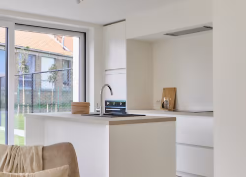 Strakke witte keuken met lange kastenwand