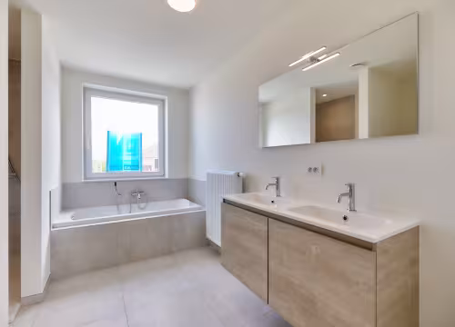 Badkamer met ligbad en dubbele wastafel
