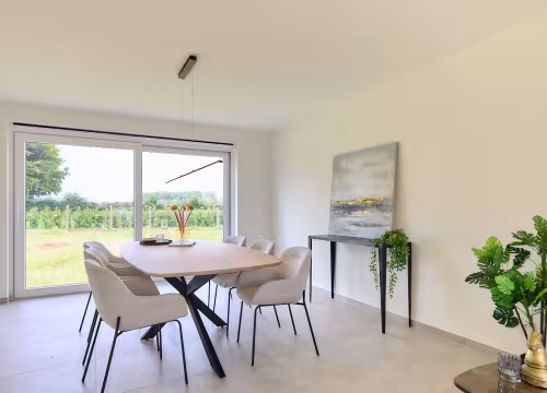 Eetruimte met tafel en stoelen bij groot schuifraam