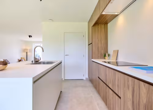 Strakke keuken met lang werkblad en houten kasten
