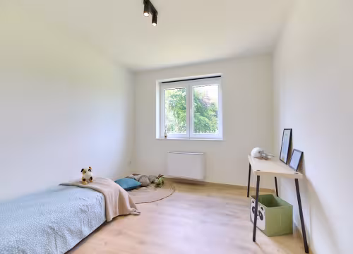 Slaapkamer met bed en werkplek, lichtrijke afwerking in Hectaar nieuwbouwwoning