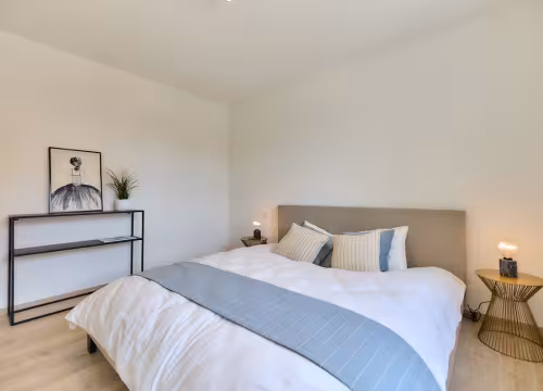 Slaapkamer met dubbel bed en rustige kleuren