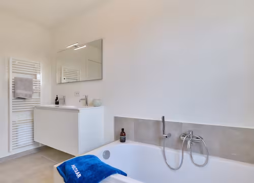 Badkamer met ligbad en kraanwerk, strakke afwerking in Hectaar nieuwbouwwoning