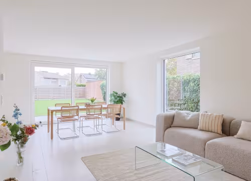Lichtrijke woonkamer en eetruimte met grote ramen in moderne nieuwbouwwoning