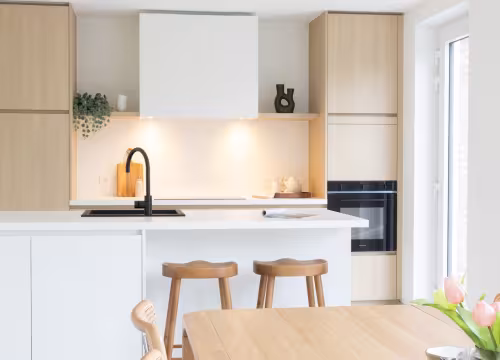 Moderne witte keuken met houten accenten in ingerichte nieuwbouwwoning