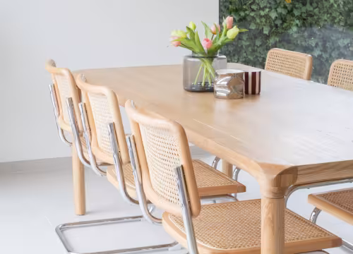 Detail van eetkamer met houten tafel in lichtrijke nieuwbouwwoning