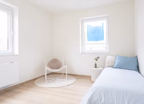 Slaapkamer in nieuwbouwwoning met houten vloer en grote raampartij